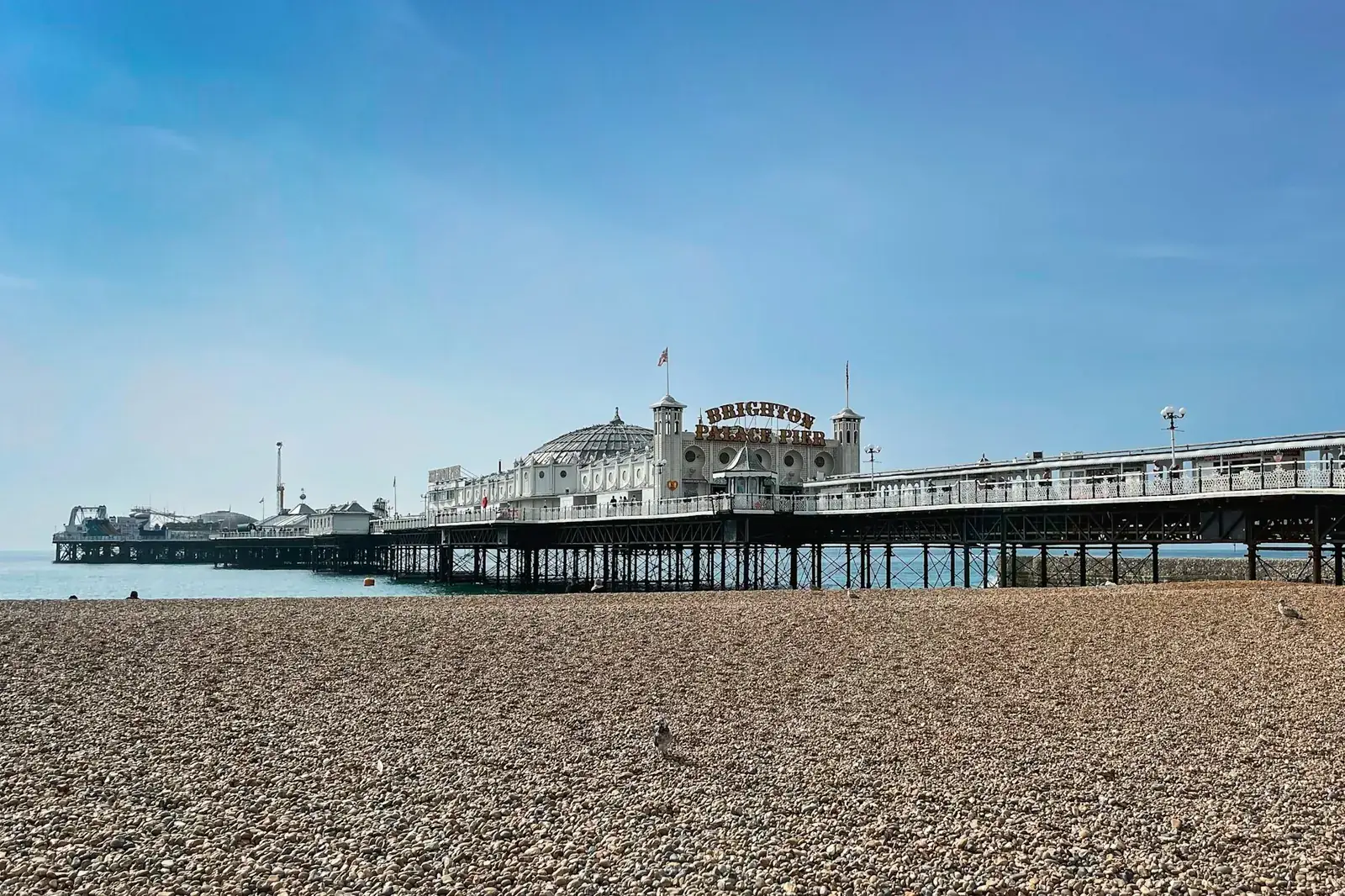 Brighton Palace Pier seen from the pebble beach on a clear day